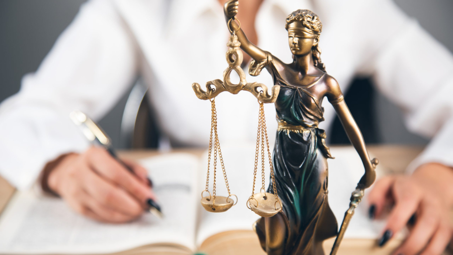 Lawyer office. Statue of Justice with scales and lawyer working